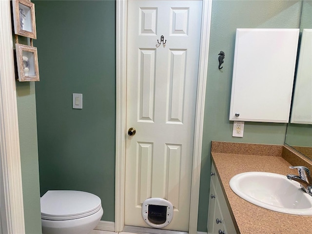 bathroom with toilet and vanity with extensive cabinet space