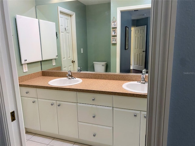 bathroom with tile flooring, oversized vanity, toilet, and dual sinks