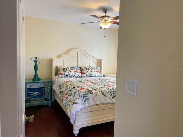 bedroom featuring dark hardwood / wood-style flooring, a textured ceiling, and ceiling fan