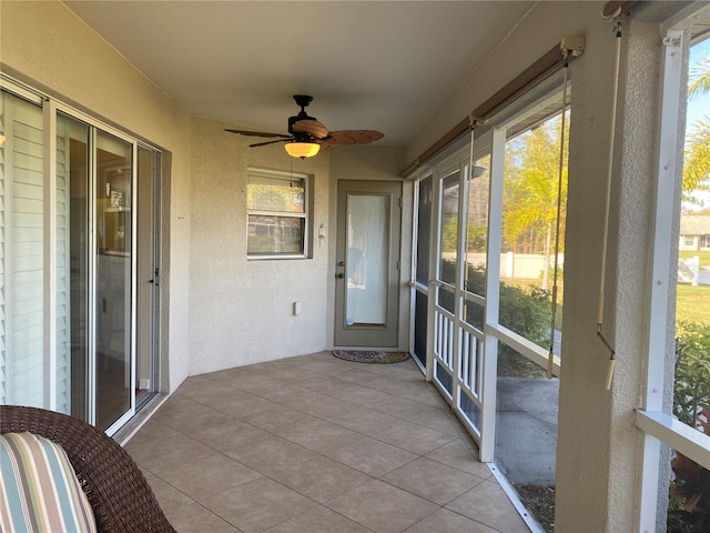 unfurnished sunroom featuring a healthy amount of sunlight and ceiling fan