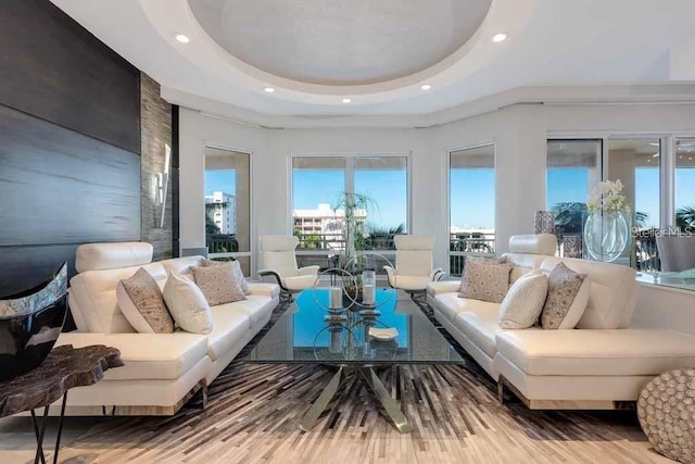 living room with a tray ceiling and light wood-type flooring