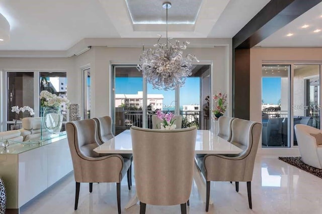 dining room featuring an inviting chandelier, a tray ceiling, and light tile floors