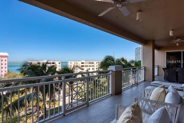 balcony with a water view and ceiling fan