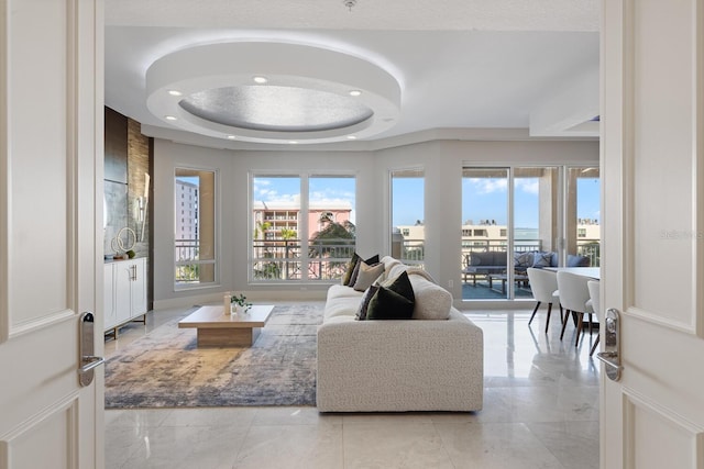 living area featuring recessed lighting and a tray ceiling