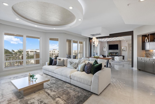 living area featuring visible vents, recessed lighting, and a tray ceiling