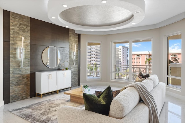 living area featuring a tray ceiling and recessed lighting