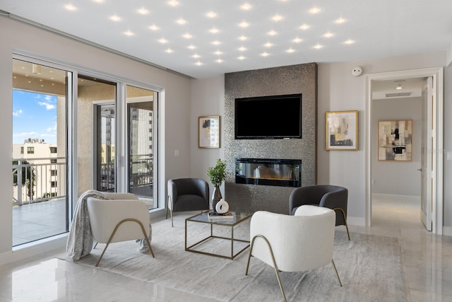 living area featuring baseboards and a large fireplace