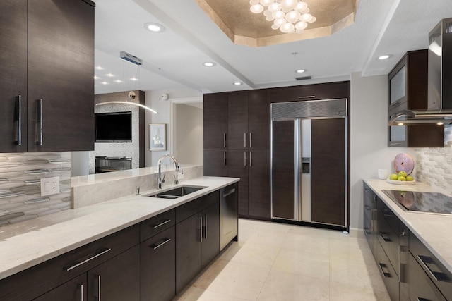 kitchen featuring paneled built in refrigerator, a sink, stainless steel dishwasher, a raised ceiling, and black electric cooktop