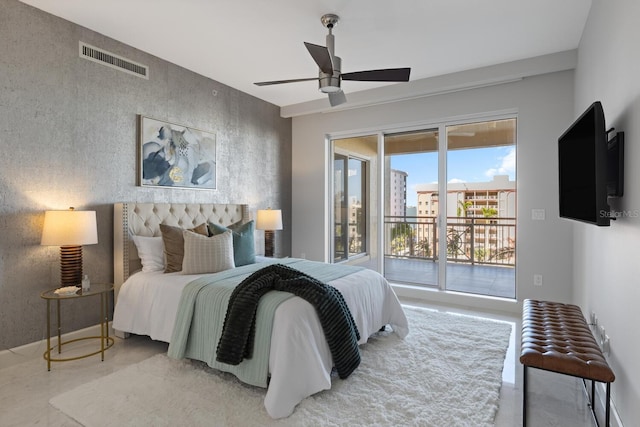 bedroom with an accent wall, access to exterior, visible vents, and ceiling fan