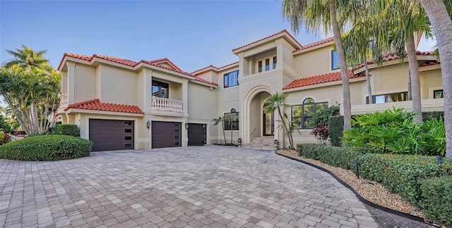 mediterranean / spanish-style home featuring a balcony and a garage