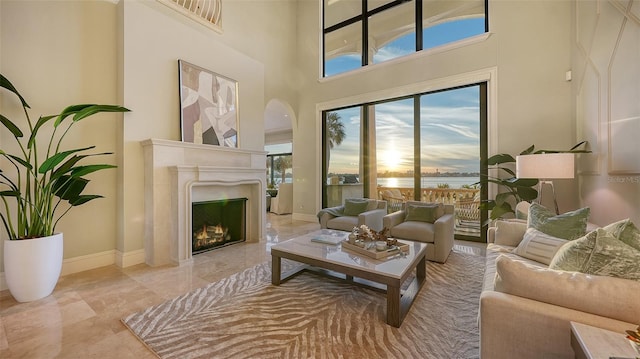 living room featuring a towering ceiling and a water view