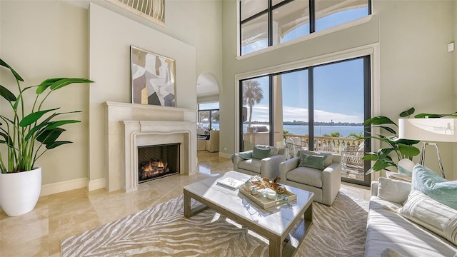 living room featuring a high ceiling and a water view