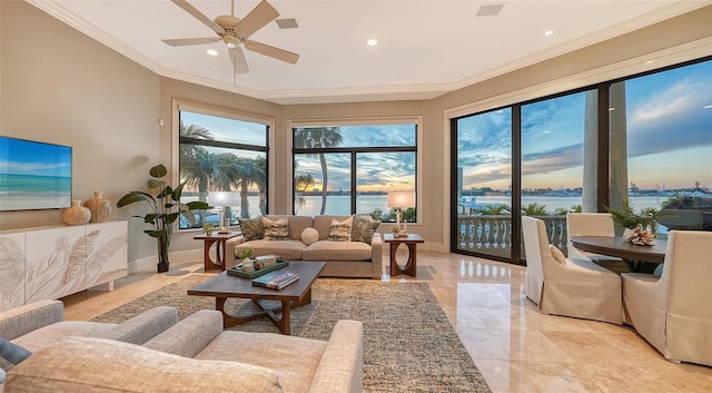 living room with a water view, ornamental molding, and ceiling fan