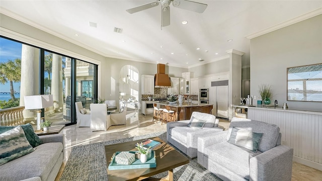 living room with ceiling fan, crown molding, and a healthy amount of sunlight