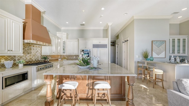 kitchen with light stone counters, a kitchen island, built in appliances, a breakfast bar area, and crown molding