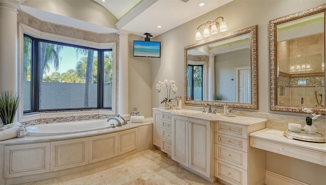 bathroom featuring vanity, decorative columns, a healthy amount of sunlight, and a bathtub