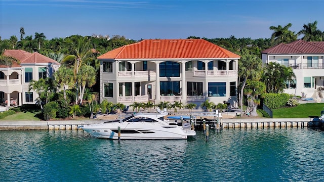 back of property with a balcony and a water view