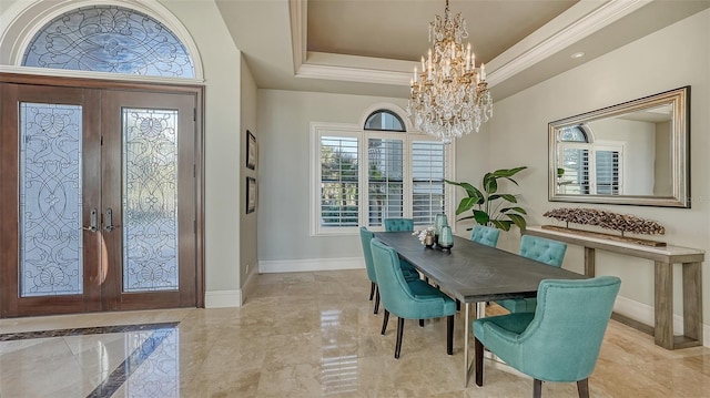 foyer with french doors, a tray ceiling, and a chandelier