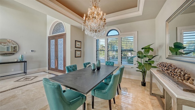 dining space with french doors, a notable chandelier, and a raised ceiling