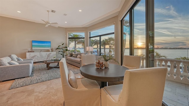 dining room with a water view, ornamental molding, and ceiling fan