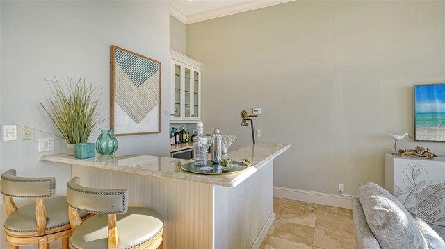 bar featuring ornamental molding and light stone countertops