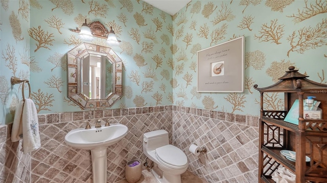 bathroom featuring tile walls and toilet