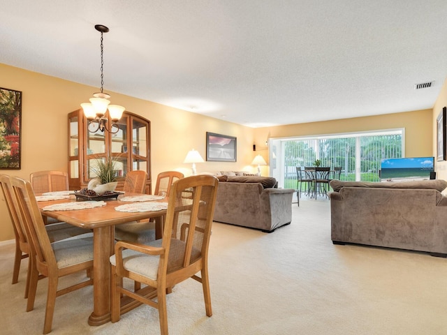 carpeted dining space featuring a textured ceiling and a notable chandelier