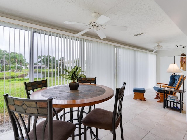 dining room with light tile floors, ceiling fan, and a wealth of natural light