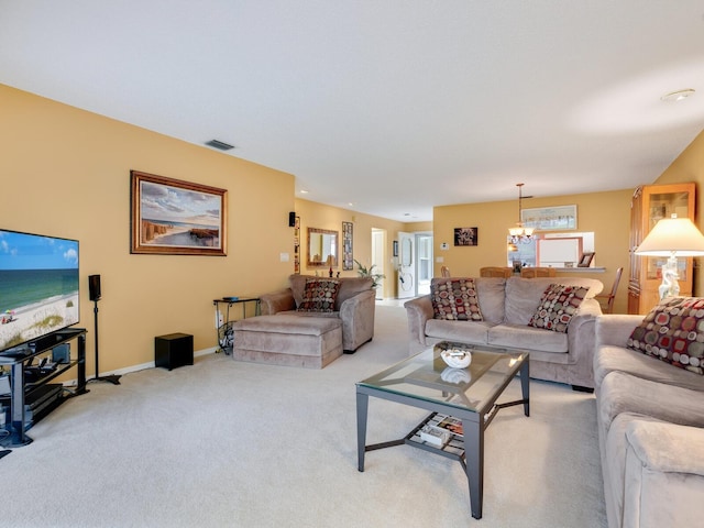 living room featuring an inviting chandelier, light colored carpet, and a water view