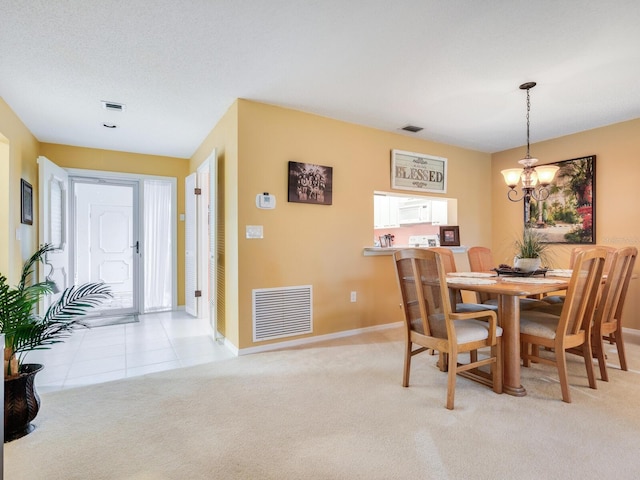 dining space featuring light colored carpet and a chandelier