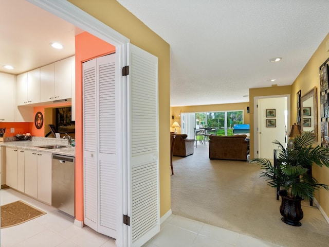 hall featuring light carpet and sink