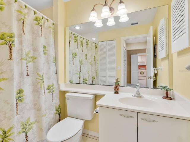 bathroom with an inviting chandelier, vanity, and toilet