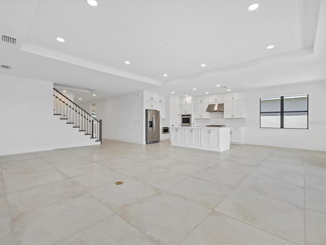 unfurnished living room with a raised ceiling