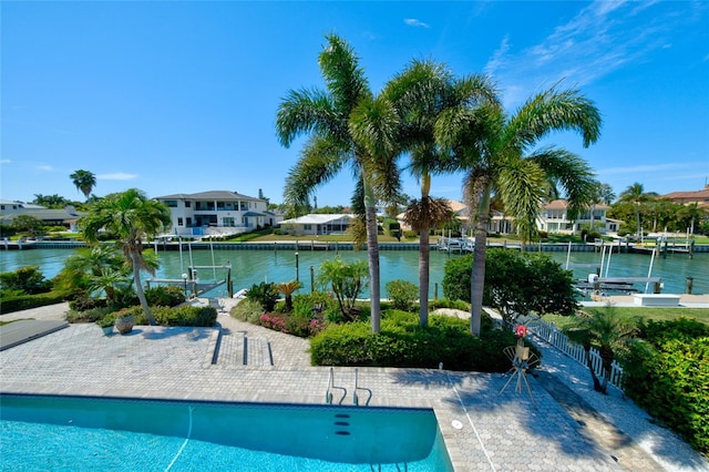 view of swimming pool with a water view and a dock