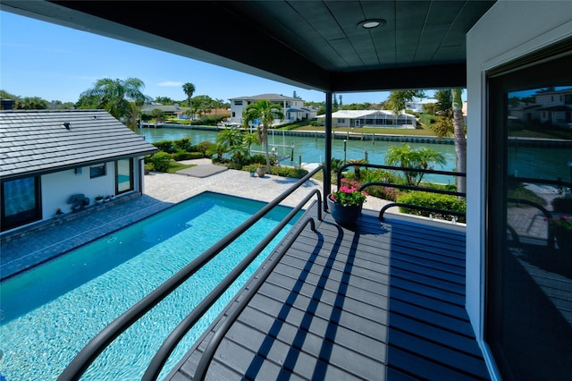 view of pool featuring a water view and a patio