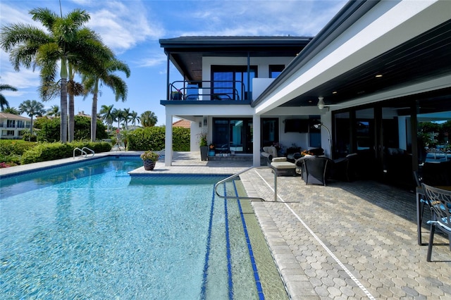 view of swimming pool featuring outdoor lounge area, a patio area, and ceiling fan