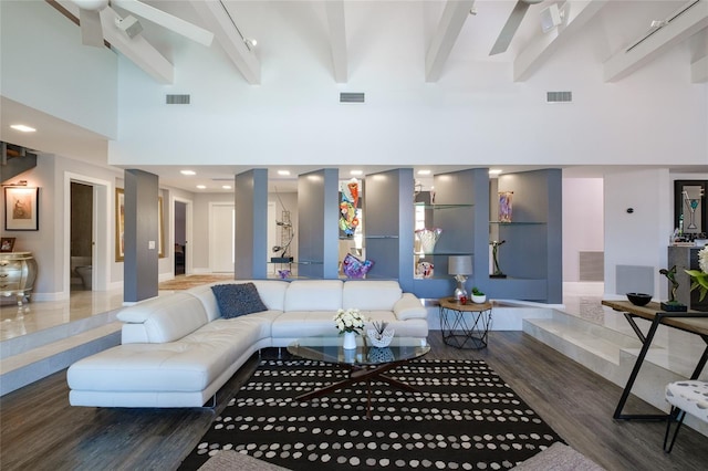 living room featuring a high ceiling, dark hardwood / wood-style floors, track lighting, and beamed ceiling