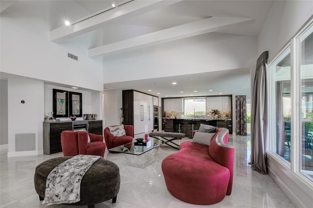 tiled living room with a towering ceiling and rail lighting