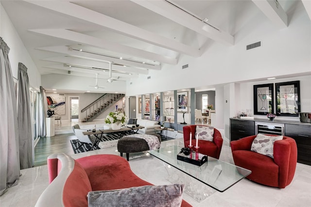 living room with beverage cooler, vaulted ceiling with beams, light wood-type flooring, and track lighting