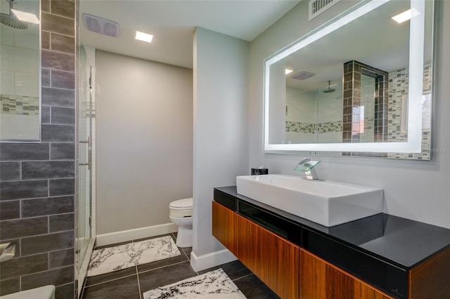 bathroom with walk in shower, tile flooring, oversized vanity, and toilet