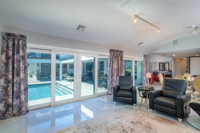 living room with light tile floors, rail lighting, ceiling fan, and vaulted ceiling