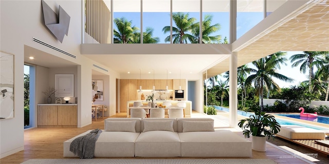 living room featuring a towering ceiling and light wood-type flooring