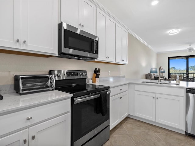 kitchen with white cabinets, stainless steel appliances, sink, and crown molding