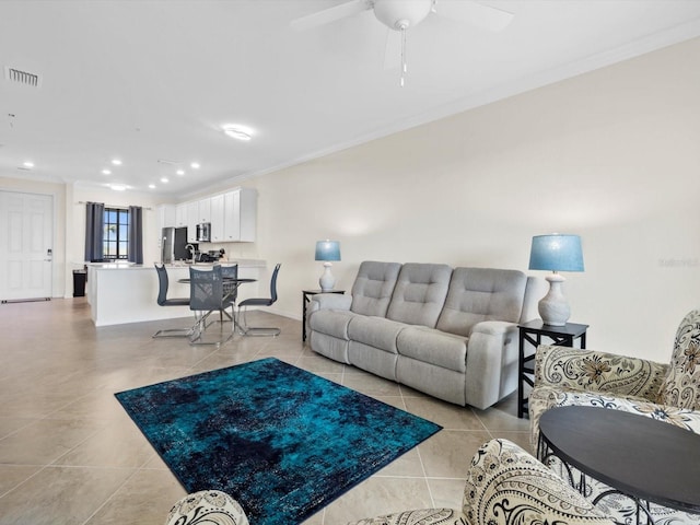 living room featuring light tile floors, crown molding, and ceiling fan