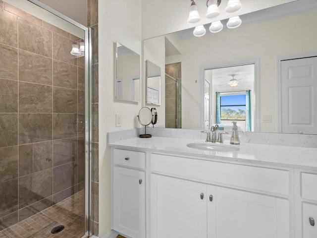 bathroom featuring a shower with door, ornamental molding, ceiling fan, and vanity