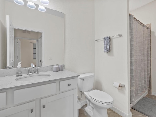 bathroom featuring vanity, tile flooring, and toilet