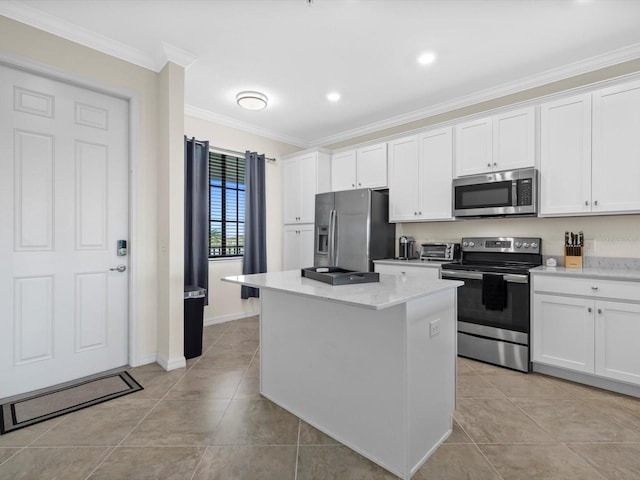 kitchen featuring light tile floors, a center island, appliances with stainless steel finishes, crown molding, and white cabinets