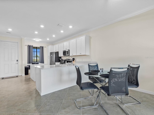 kitchen featuring ornamental molding, white cabinetry, a breakfast bar area, and stainless steel appliances