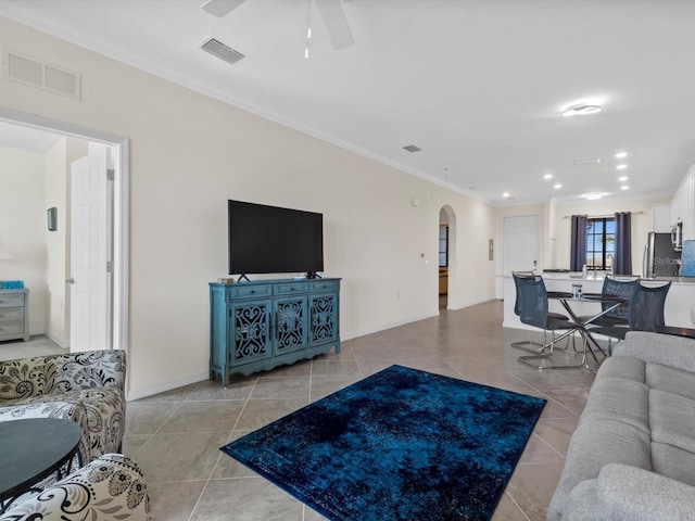 living room featuring light tile flooring, ceiling fan, and crown molding