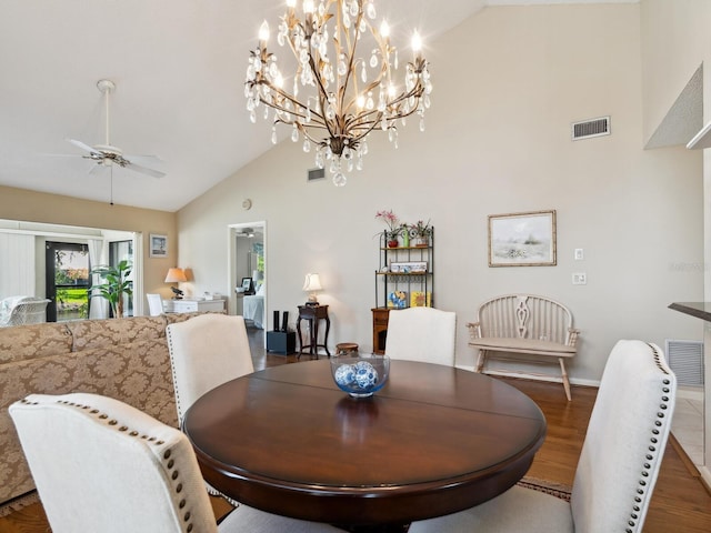 dining room with high vaulted ceiling, dark hardwood / wood-style floors, and ceiling fan with notable chandelier